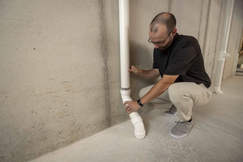 Technician Installing Commercial Radon Mitigation System