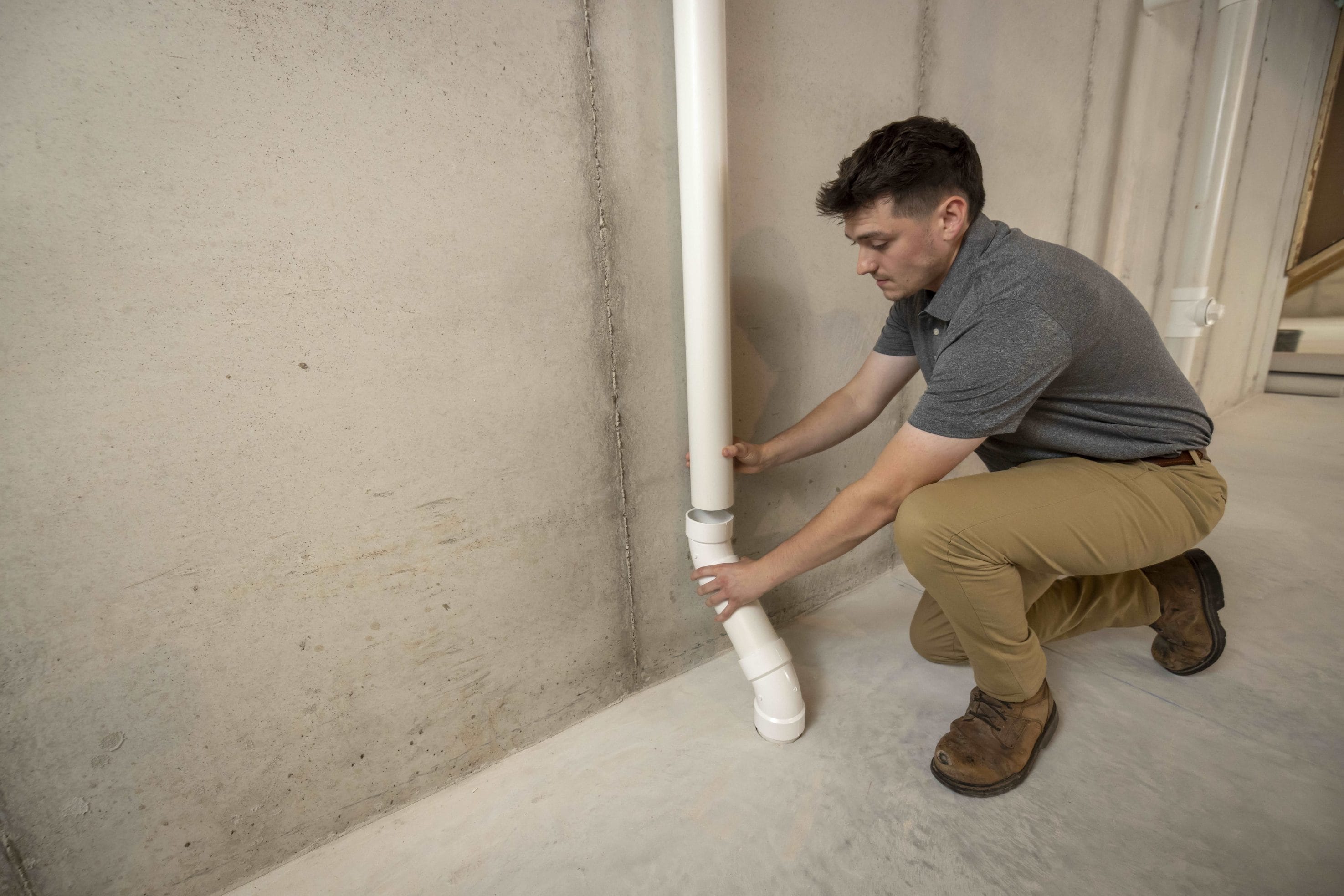 Technician Installing Commercial Radon Mitigation System
