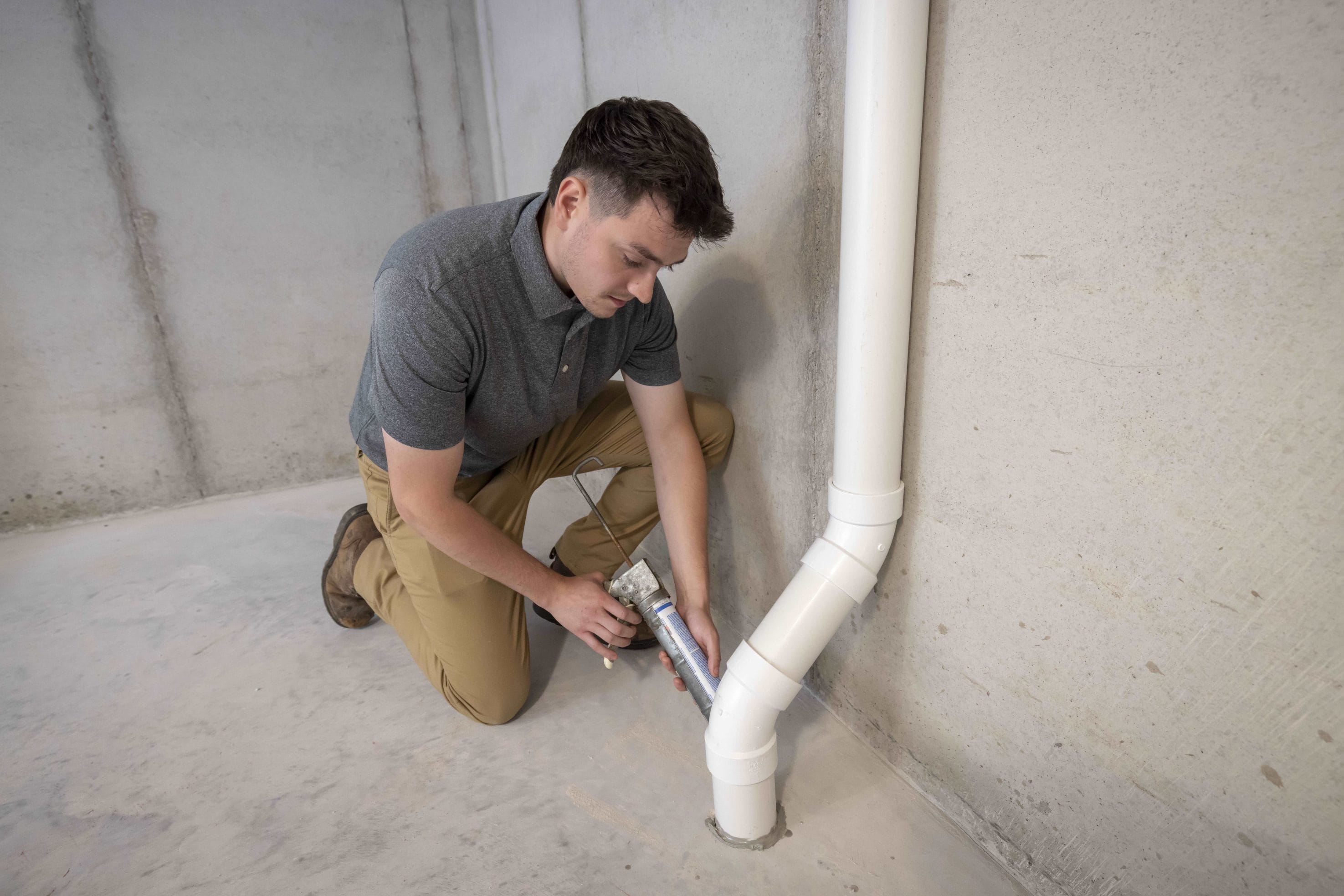 Technician Repairing Basement radon mitigation system
