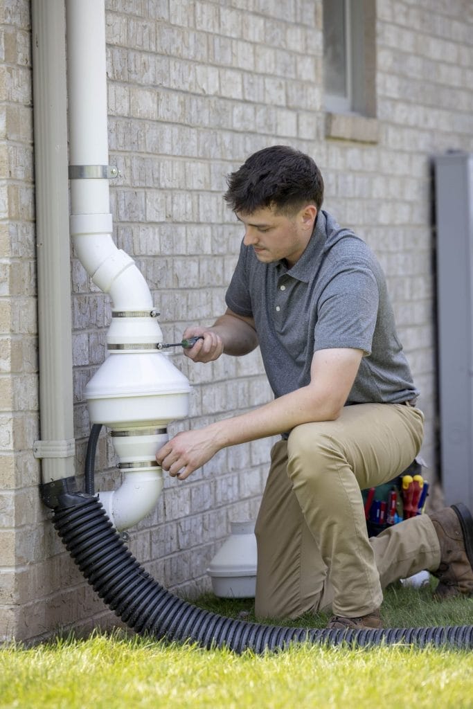 Radon mitigation technician inspecting system in New Mexico