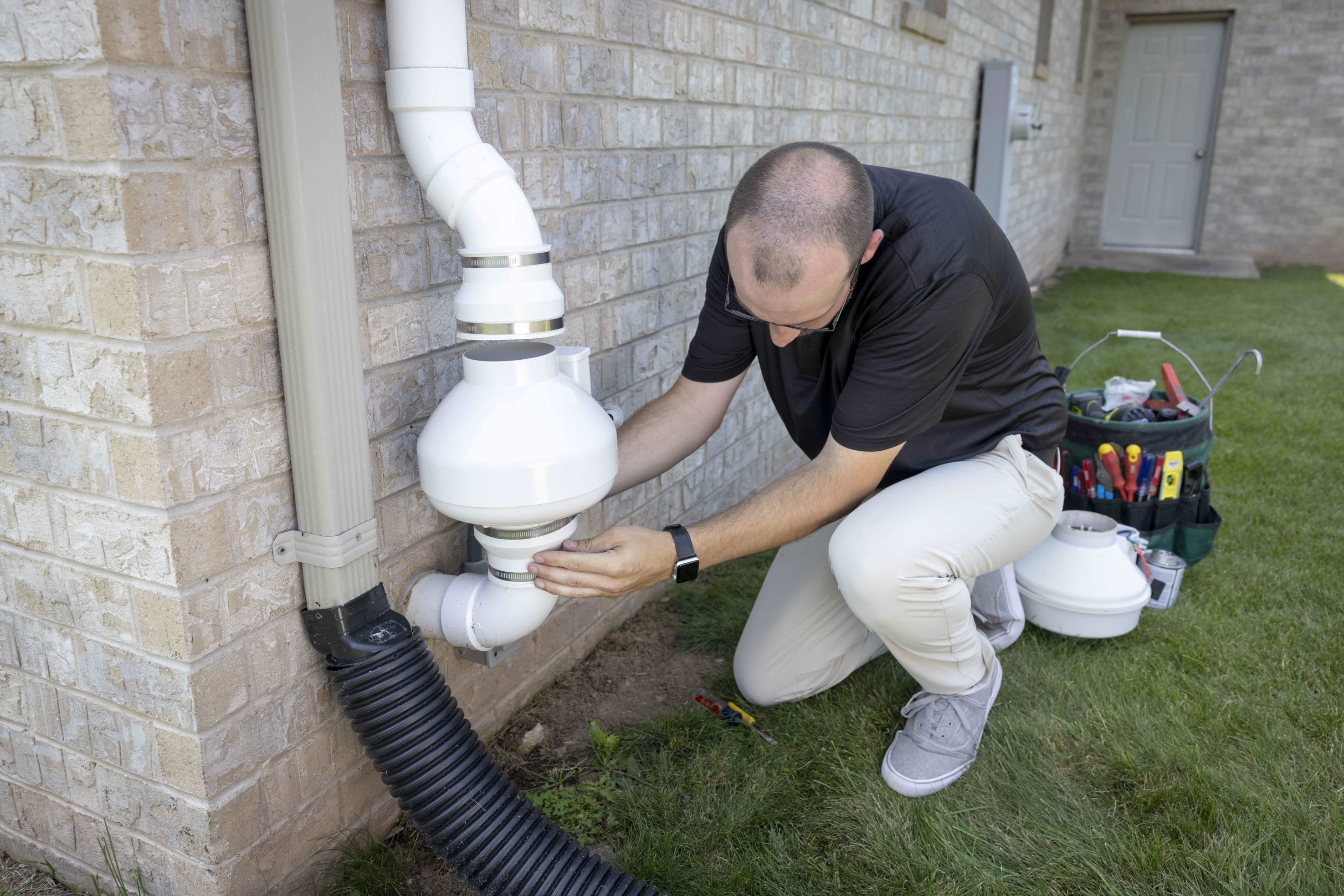 Technician Inspecting Home Radon System Repair
